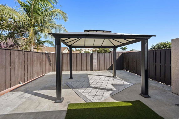 Backyard area with a gazebo and wooden fence.