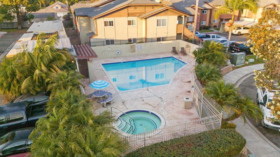 Swimming pool area with a rectangular pool adjacent to residential buildings.
