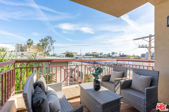 View from a balcony overlooking a cityscape with outdoor seating.