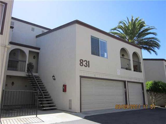 Front view of a two-story building with garage doors and external staircase.