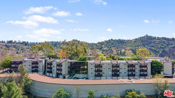Front view of a large multi-story residential building complex with multiple balconies.