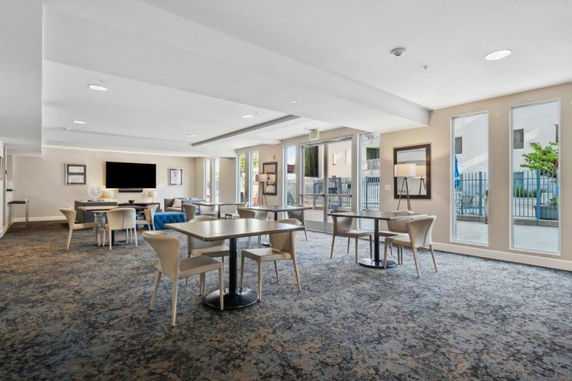 Interior of a recreational club house with tables, chairs, and a television.