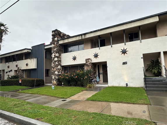 Front view of a two-story apartment building with decorative star accents and stone chimney features.