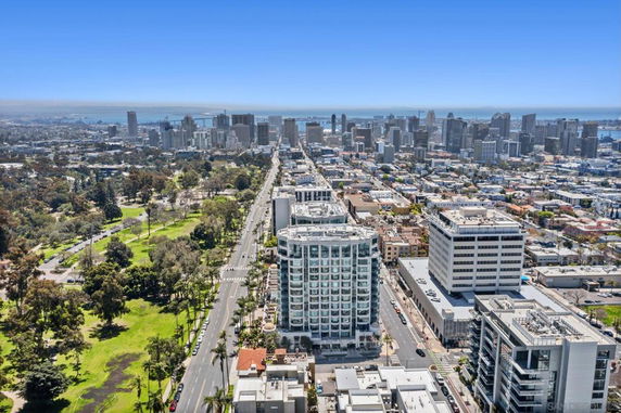 Panoramic view of a city with high-rise buildings and green park areas.