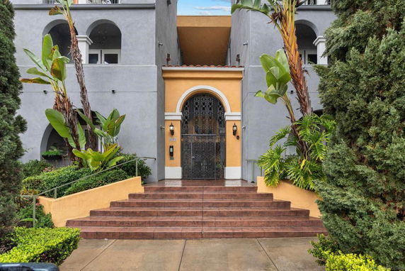 Front view of a building with steps leading to an ornate entrance.
