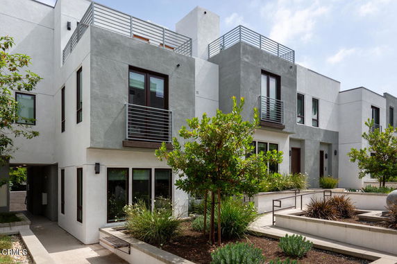 Front view of a modern multi-story apartment building with balconies.