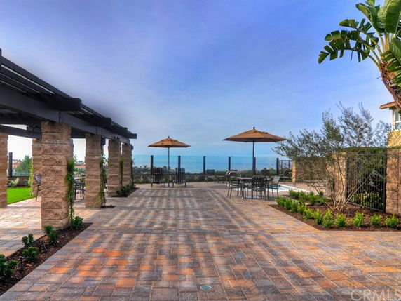 Outdoor patio area with seating and umbrellas overlooking the landscape.
