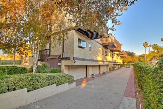 Front view of a multi-story building with balconies and garage entrances.