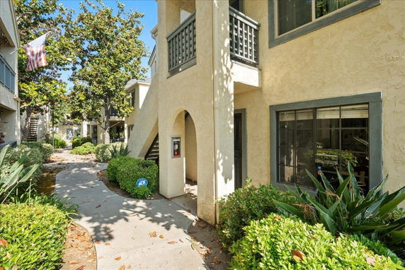 Front view of a two-story apartment building with a walkway and stairs.