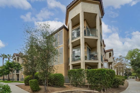 Front view of a multi-story residential building with balconies.