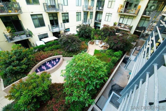 Aerial view of a courtyard area with lush greenery and apartment balconies.