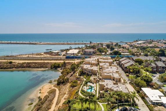 Aerial view of a coastal residential area with visible buildings and the ocean in the background.