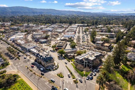Aerial panoramic view of an urban area with mountains in the background.