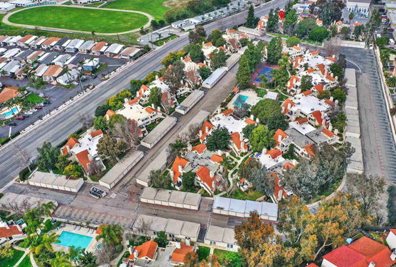Aerial view of a residential complex with multiple buildings and a swimming pool.