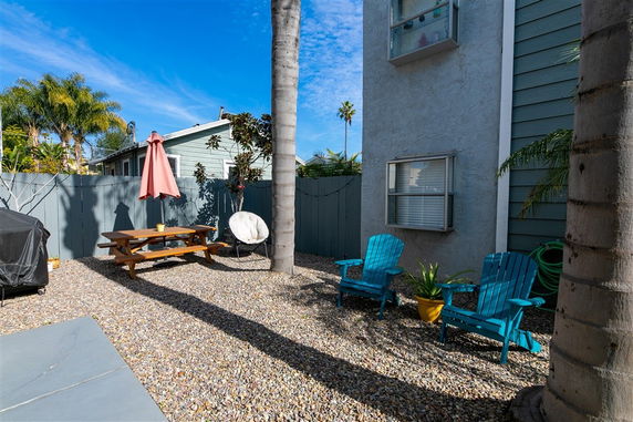 Outdoor seating area with chairs and an umbrella near a building.