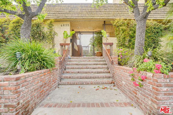 Front view of a house with a staircase and brick walls.