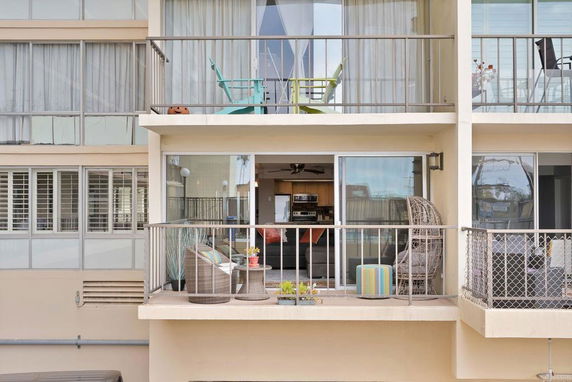 Exterior view of a multi-story building with balconies and glass sliding doors.