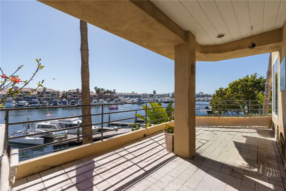 View of a waterfront area with boats and buildings in the background seen from a patio.