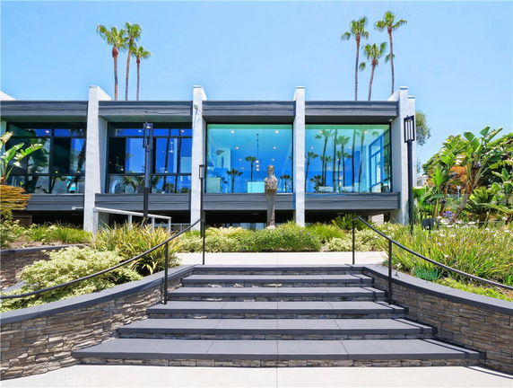 Front view of a modern two-story house with large glass windows.