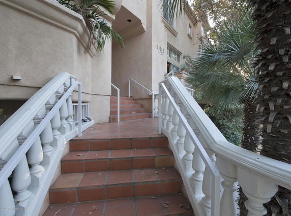 Front entrance of a building with terracotta steps leading to a doorway.