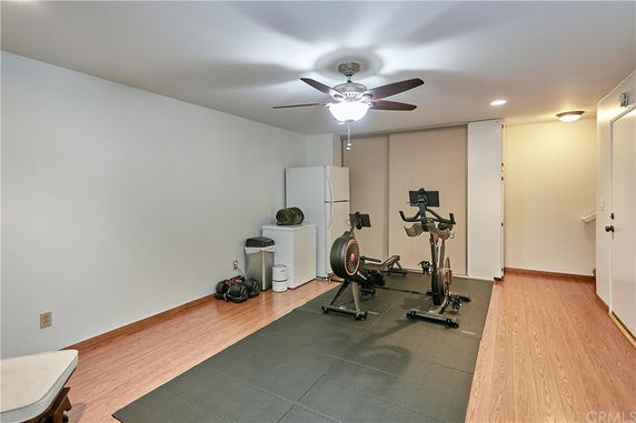 Indoor room with exercise bikes and a refrigerator, set up for home gym use.