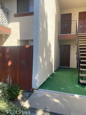 Front view of an apartment building with stair access to the second floor.
