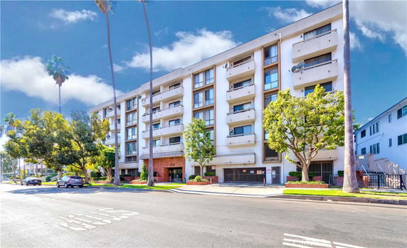 Front view of a multi-story apartment building with balconies.