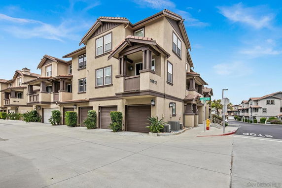 Front view of a multi-story residential building with garages and balconies.