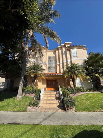 Front view of a multi-story house with a central entrance and decorative facade.