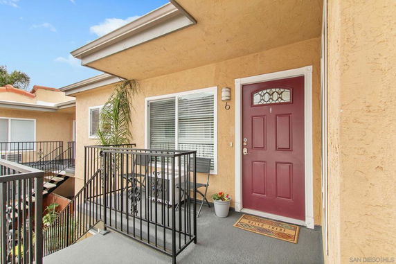 Front view of a house entrance with a red door and a small porch area.