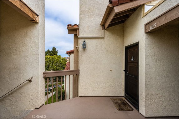 Front view of an entrance to an apartment with beige walls and a dark wooden door.