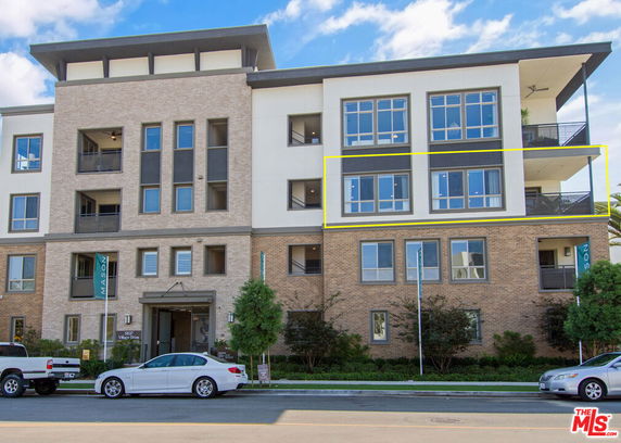 Front view of a multi-story building with large windows and balconies.