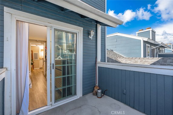 View of a rooftop area with a sliding door leading into the interior of a house.