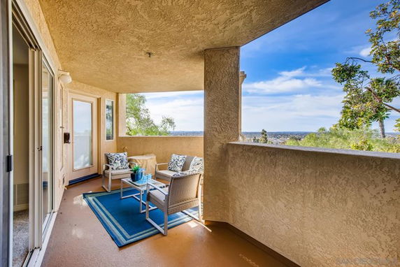 Covered patio area with outdoor seating and a panoramic view of the surrounding landscape.