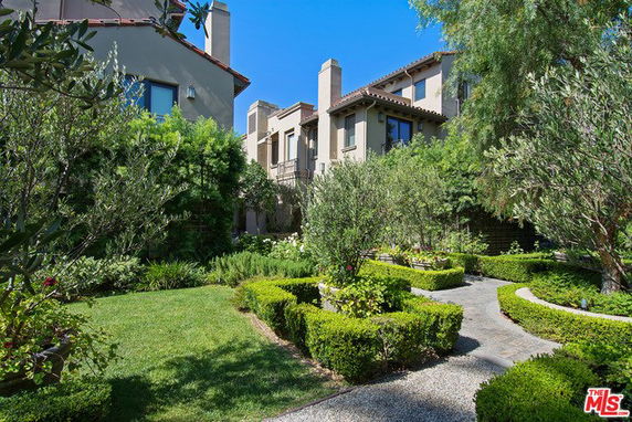 Front view of a multi-story house with a landscaped garden.