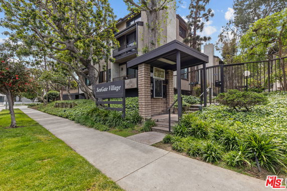 Front view of a multi-story residential building with a gated entrance.