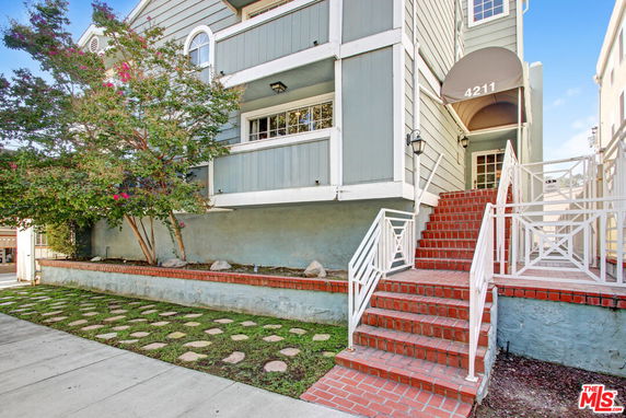 Front view of a multi-story house with brick staircase and entryway.