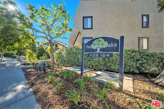 View of a residential building with a sign reading 'Piedmont Oaks'.