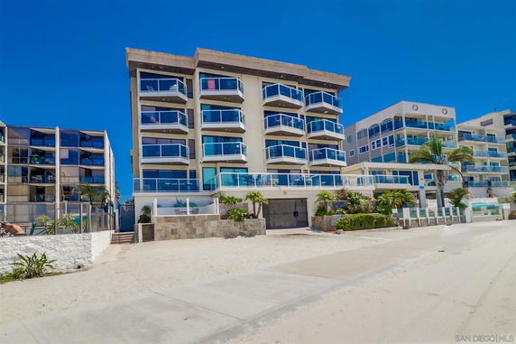 Front view of a multi-story beachfront building with balconies.
