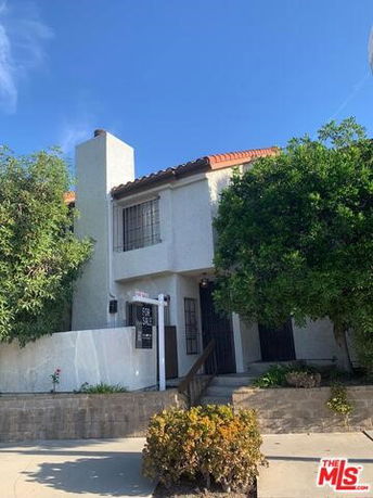 Front view of a two-story house with a chimney and tiled roof.