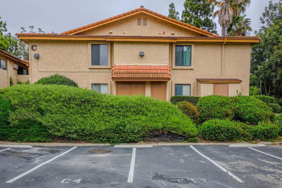 Front view of a two-story apartment building with a tiled roof.
