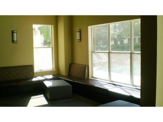 Indoor room with seating area and large windows overlooking an outdoor area.