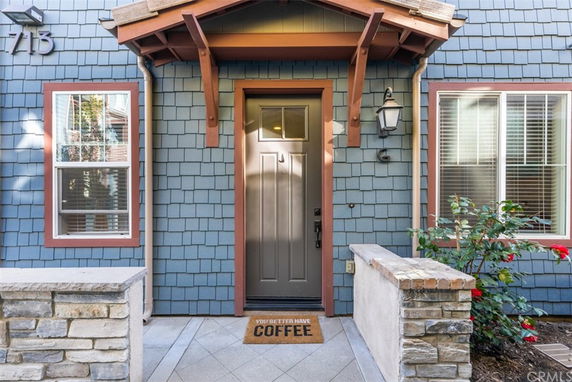 Front entryway of a house with blue exterior siding and red trim around windows.