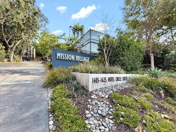 Entrance sign of a commercial or residential complex with the name 'Mission Village' and address '1605-1625 Hotel Circle South'.