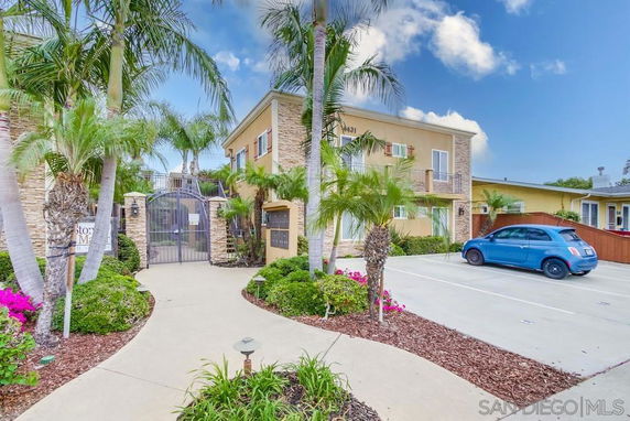 Front view of a two-story apartment building with a gated entrance.