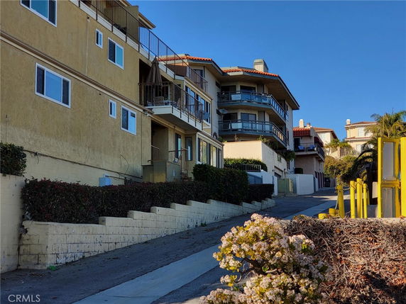 Front view of a multi-story building with balconies on an incline.