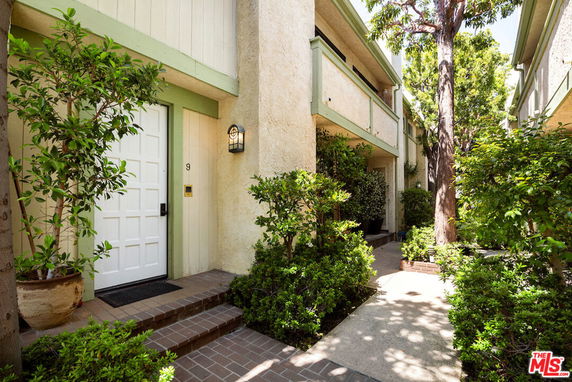 Front view of a two-story building entrance with a white door and green trim.