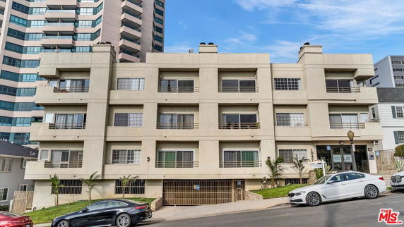 Front view of a multi-story apartment building with balconies.