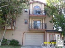 Front view of a multi-story house with a double garage and balconies.