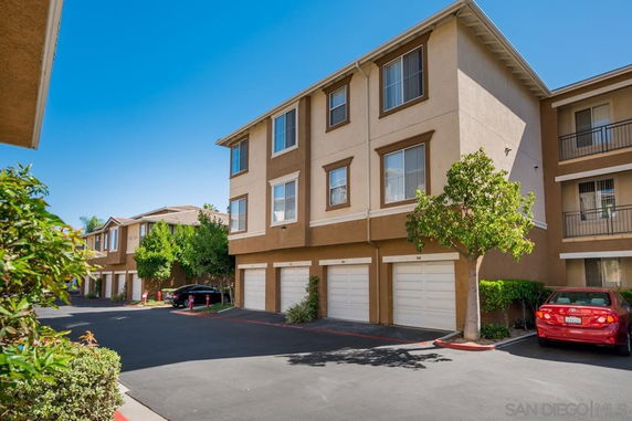 Front view of a multi-story residential building with garages.